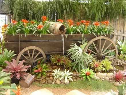 jardim rústico roda de carroça e fonte