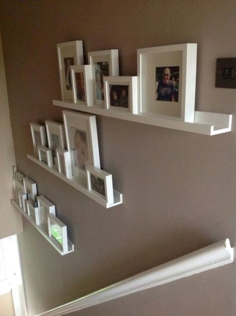 decoração de escada com fotos em estantes