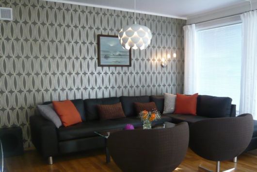 salas com sofá preto com papel de parede