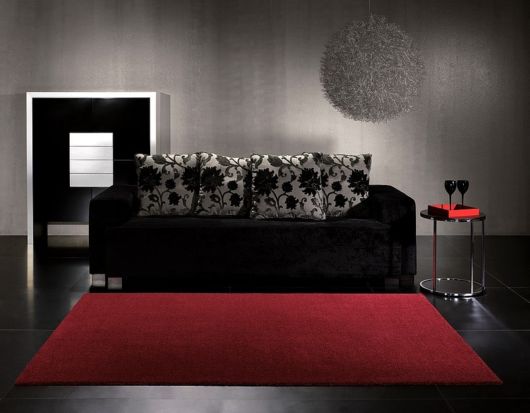 salas com sofá preto com tapete simples