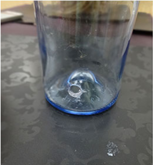 garrafa de vidro com furo na lateral próximo ao fundo