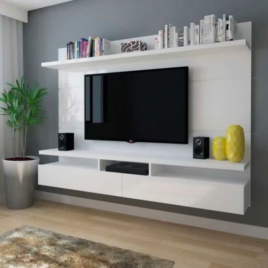 móvel planejado branco de painel com prateleiras e aparador em torno de TV