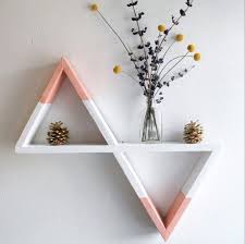 Modelo de nicho triangular em parede branca, nos tons de rosa e branco.