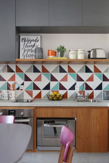 Cozinha com móveis de madeira e papel de parede com triângulos coloridos.