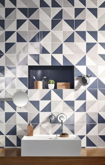 Papel de parede geométrico com triângulos brancos, azuis e cinzas em banheiro.