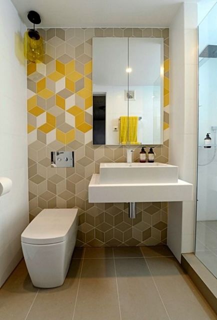 Banheiro com papel de parede geométrico degradê.