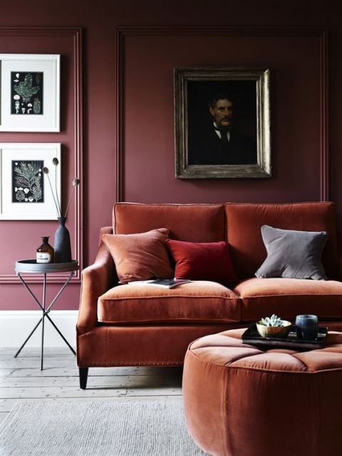 sofá de veludo marrom com parede vinho ao fundo