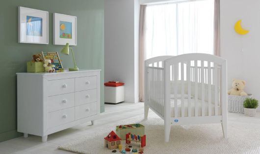 quarto de bebê verde com móveis brancos