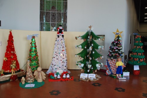 árvores de Natal de diferentes estilos em corredor de escola