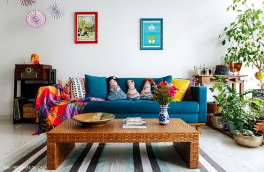 Sofá azul em sala de estar, com almofadas coloridas.