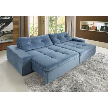 Sala com paredes de madeira, piso claro e sofá azul.
