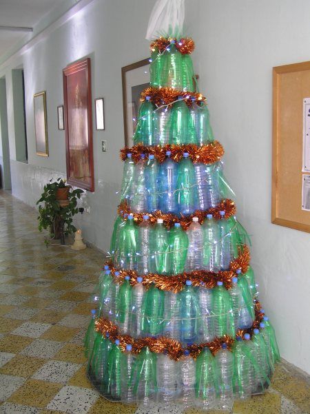 árvores de Natal diferentes feitas com garrafas PETs de pé