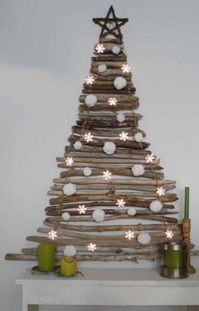 árvore de Natal na parede sobre móvel feita com gravetos