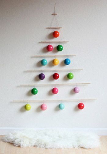 árvore de Natal na parede feita com uma varalzinho e decorado com bolas coloridas