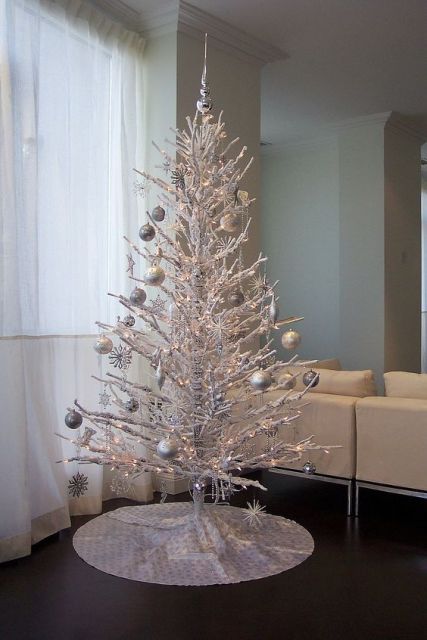 Árvore de Natal branca com bolas prateadas.