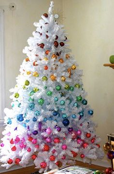 Árvore de Natal branca com bolas formando um degradê colorido.