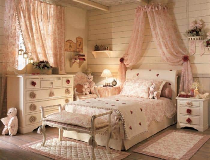 Quarto feminino em tons pastéis com cortinas de renda rosê.