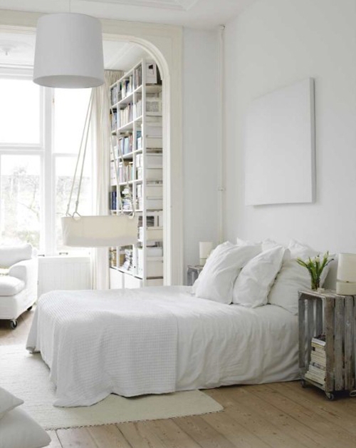 Quarto feminino branco com estante delicada no mesmo tom.