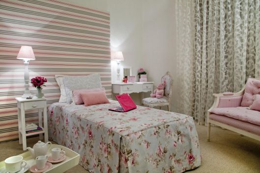 Modelo de quarto na cor branco com papel de parede colorido nas cores branco, rosa e cinza.
