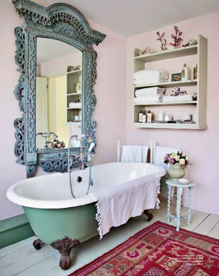Banheiro com banheira verde e espelho vintage azul emoldurado.