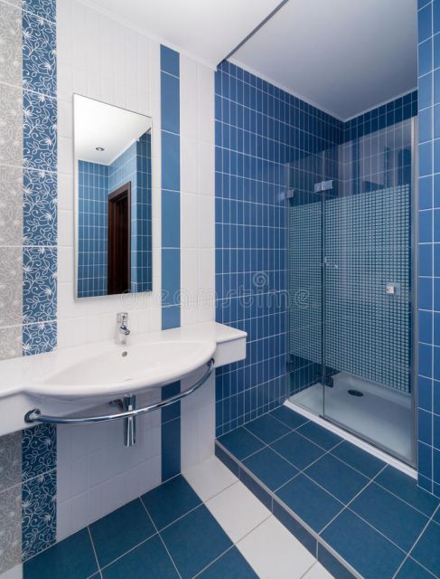 Banheiro azul escuro com detalhes na cor branca.