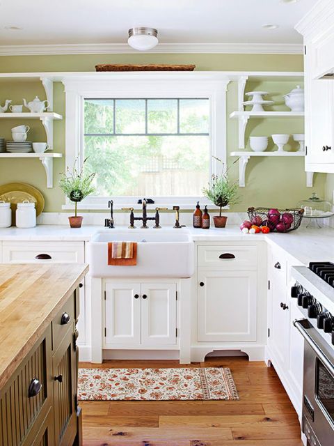 Modelo de cozinha com armarios brancos e paredes na cor verde.