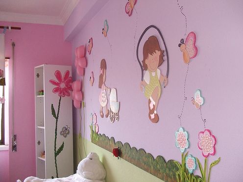 Quarto com paredes rosa e lilás e móveis brancos.