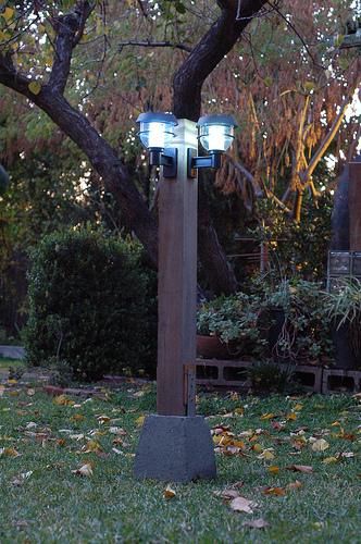 Luminárias solares instaladas em um poste no jardim. 