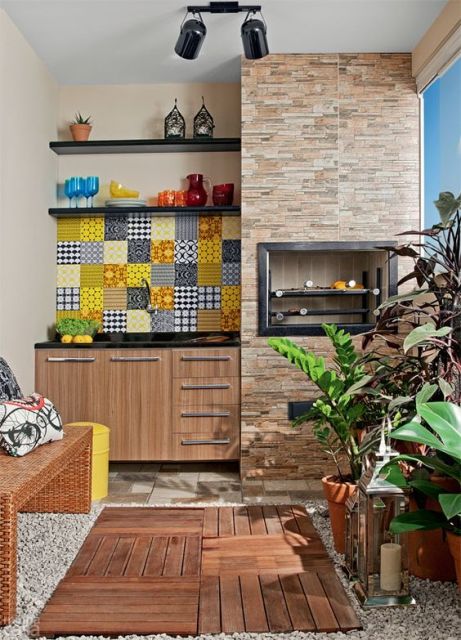Foto de uma varanda gourmet pequena com um pequeno armário ao lado de uma churrasqueira, piso de madeira, plantas e parte da parede decorada com porcelana,
