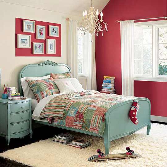 Quarto com parede vermelha, mural na mesma cor e cama vintage com cômoda no mesmo estilo na cor azul.