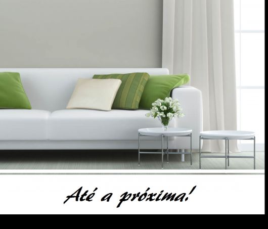sofá branco com almofadas na cor verde e branco.