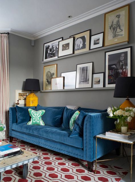 Sala cinza com sofá azul escuro.