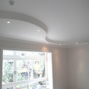 Rodapé de gesso para teto instalado de forma curvilínea com pequenas lâmpadas ao longo de sua extensão.  