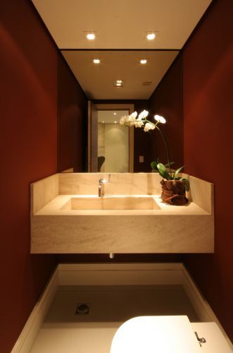 Foto de uma pia de banheiro com um espelho e um rodapé de gesso simples instalado nas três paredes abaixo dela. 