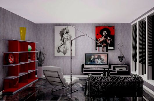 Sala de estar com uma televisão ligada transmitindo um clipe do Guns n Roses e na parede há quadros de outras bandas de rock. 