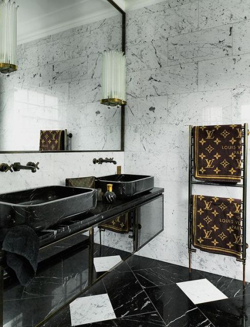 Foto de um lavabo com bancada que suporte duas cubas e duas torneiras de parede com um espelho amplo. 
