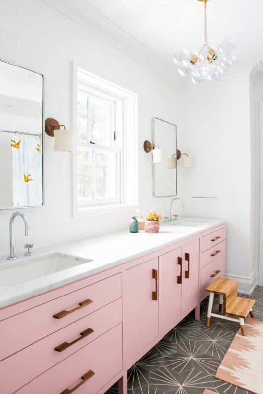 Banheiro branco com armário rosa e pendente de lampadas 1