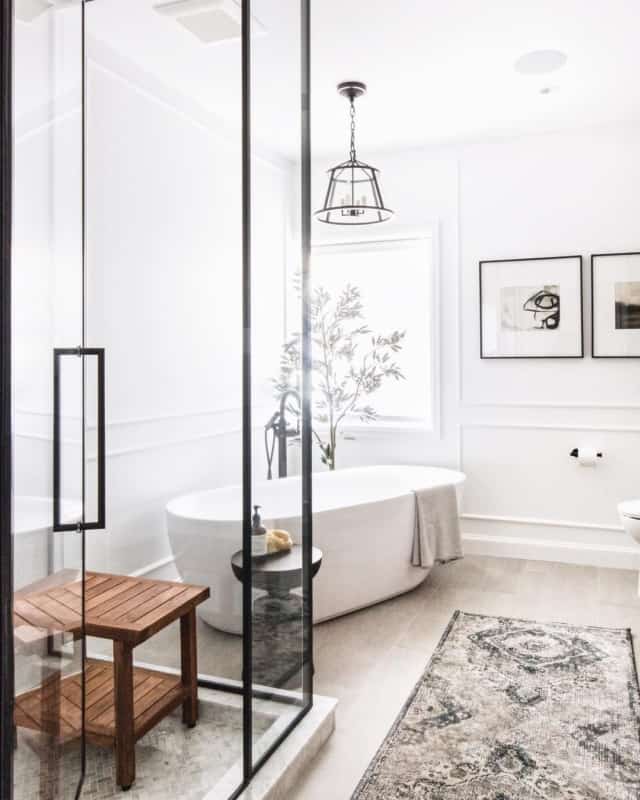 Banheiro branco com banheira e luminária pendente