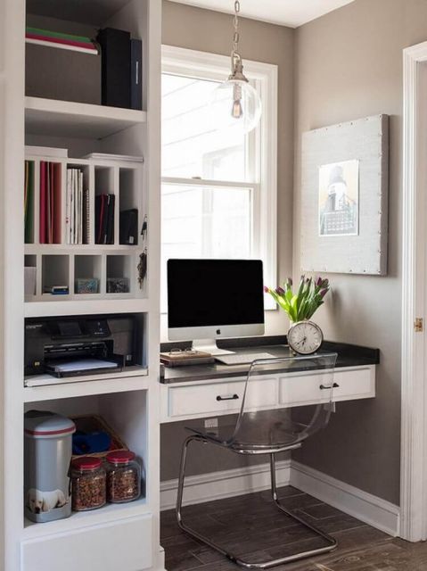 Uma escrivaninha suspensa de canto com gavetas e acoplada a uma estante que também é fixa na parede