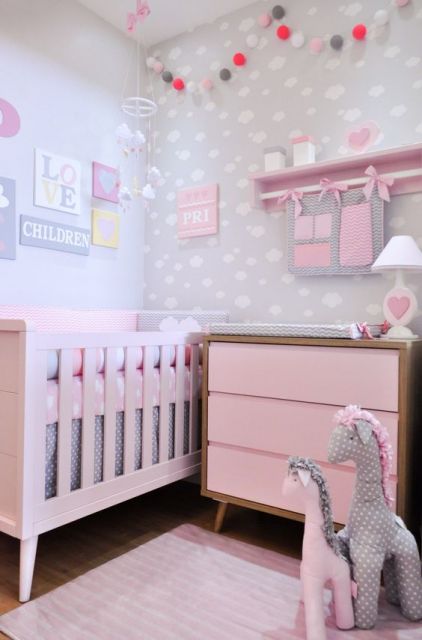 Quarto com móveis e enfeites para quarto de bebê rosa.