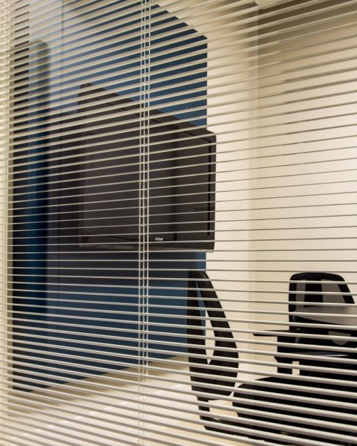 Divisória de vidro para escritório com persiana.