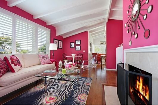parede rosa em sala com lareira e TV
