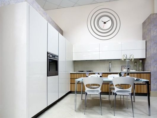 cozinha branca com relogio de parede espiral.