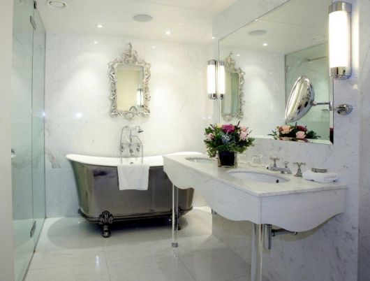 Banheiro com banheira e espelho provençal
