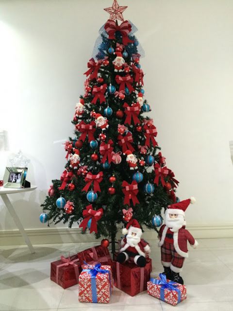 Árvore de Natal média com muitos laços vermelhos