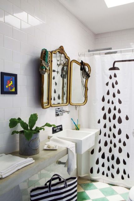 Banheiro com cortina de box com desenho de chuveiro.