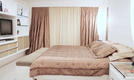 Cortina e colcha com tecidos e cores iguais é uma tendência para decorar quarto de casal
