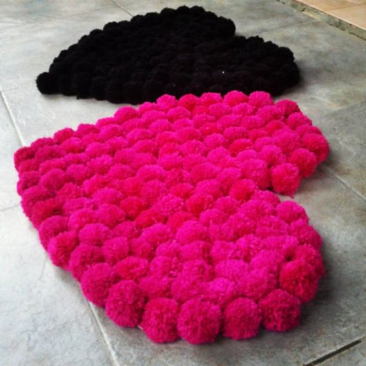 modelo de tapetes de coração de pompons nas cores rosa e preto.