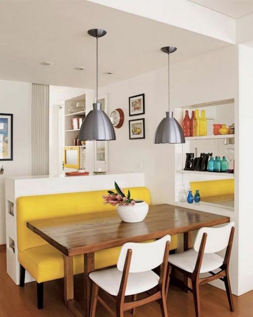 Esse sofá de capitonê amarelo combina bastante com a mesa de madeira e as luminárias cinzas