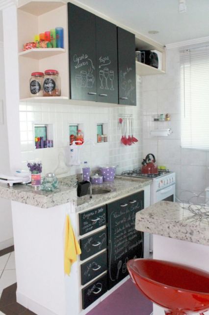 Cozinha com azulejos brancos e móveis pretos.